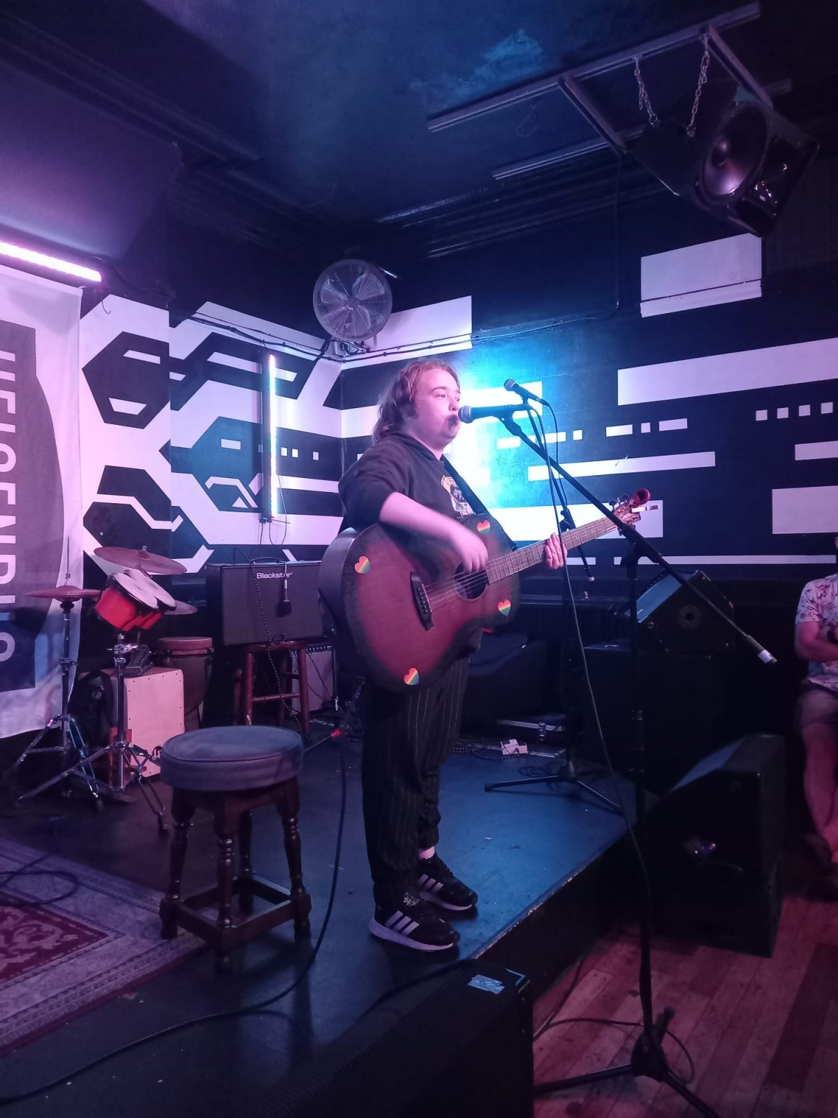 An image of a musician singing and holding a guitar