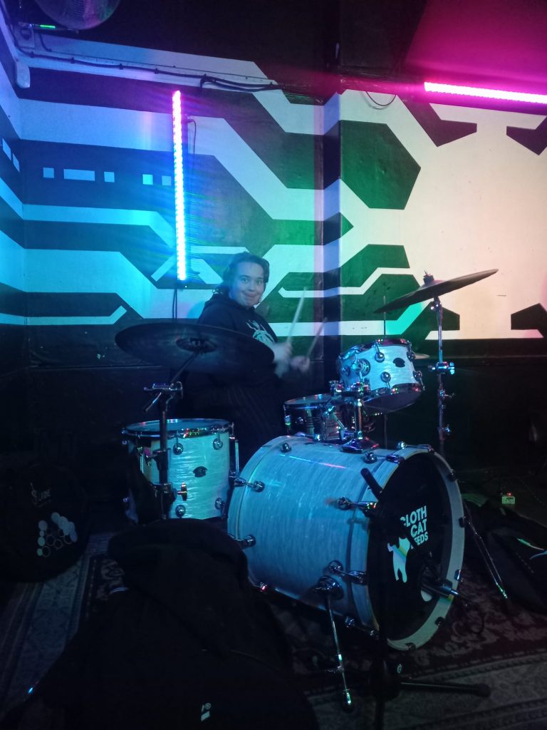 An image of Jack playing the drums and pulling a funny face.